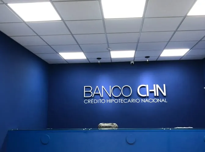 Sala con luminarias LED empotradas en el cielo falso y una pared azul con rótulo corporativo