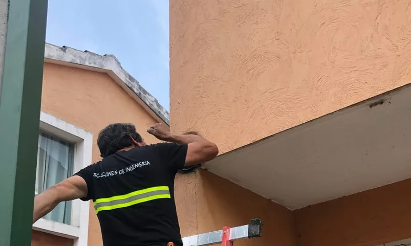 Técnico de SDI trabajando junto a la fachada de un edificio