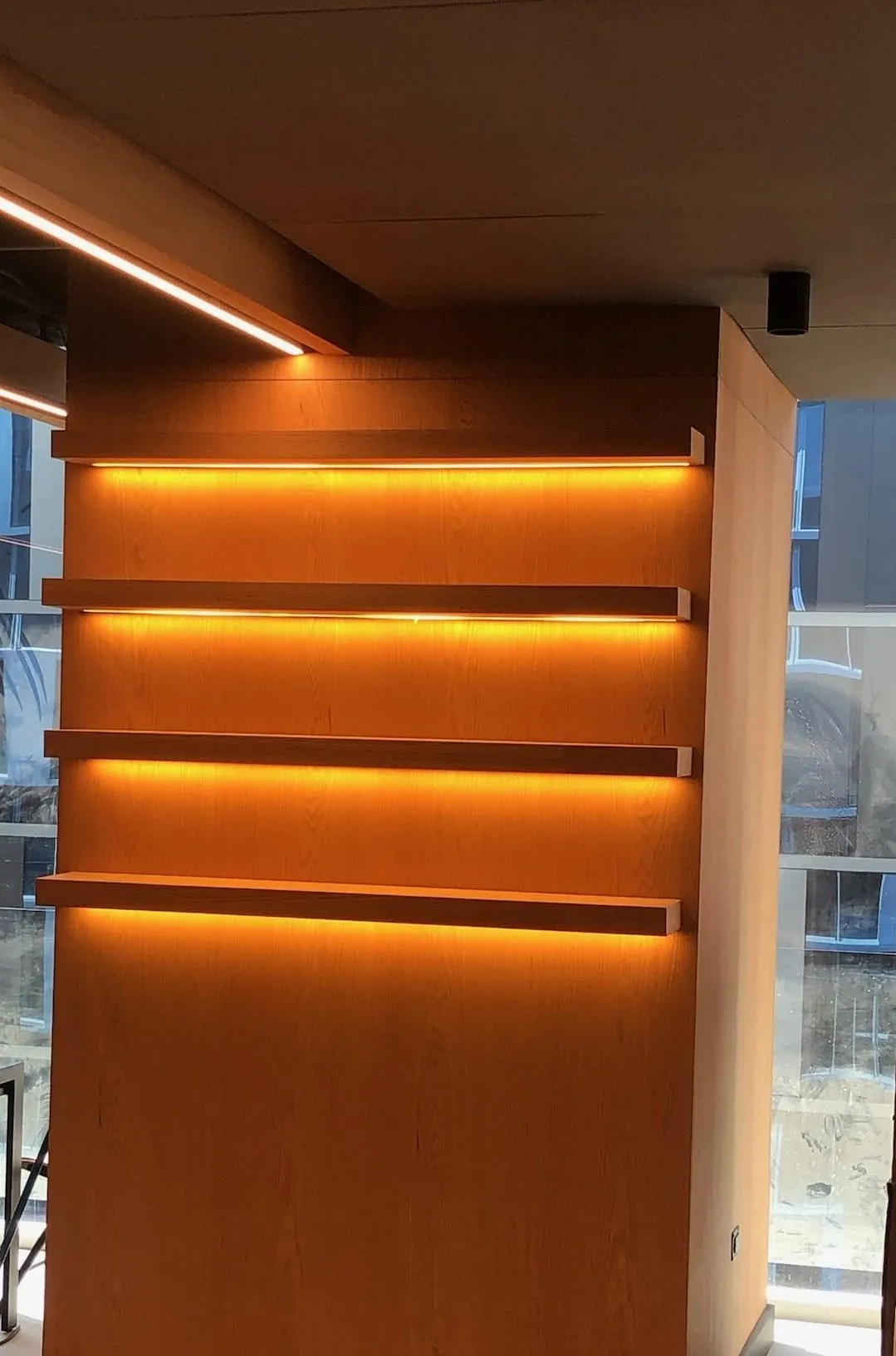 Panel de madera con repisas iluminadas con LED cálido