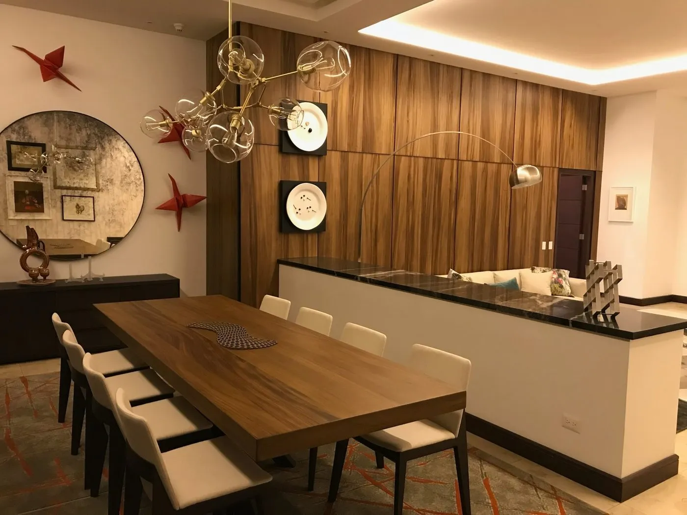 Comedor con mesa de madera, luminaria decorativa e iluminación LED perimetral en el cielo