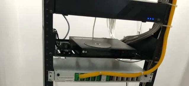 Equipo sobre un panel del rack con cable amarillo conectado