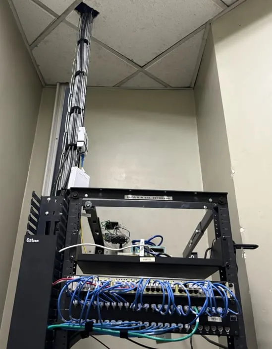 Rack abierto con cableado estructurado de cables azules conectado a un patch panel